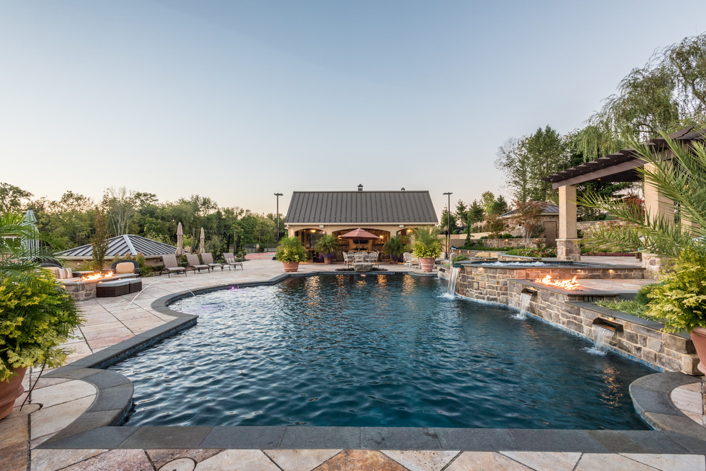 Ejemplo de piscinas y jacuzzis alargados tradicionales grandes a medida en patio trasero con adoquines de hormigón
