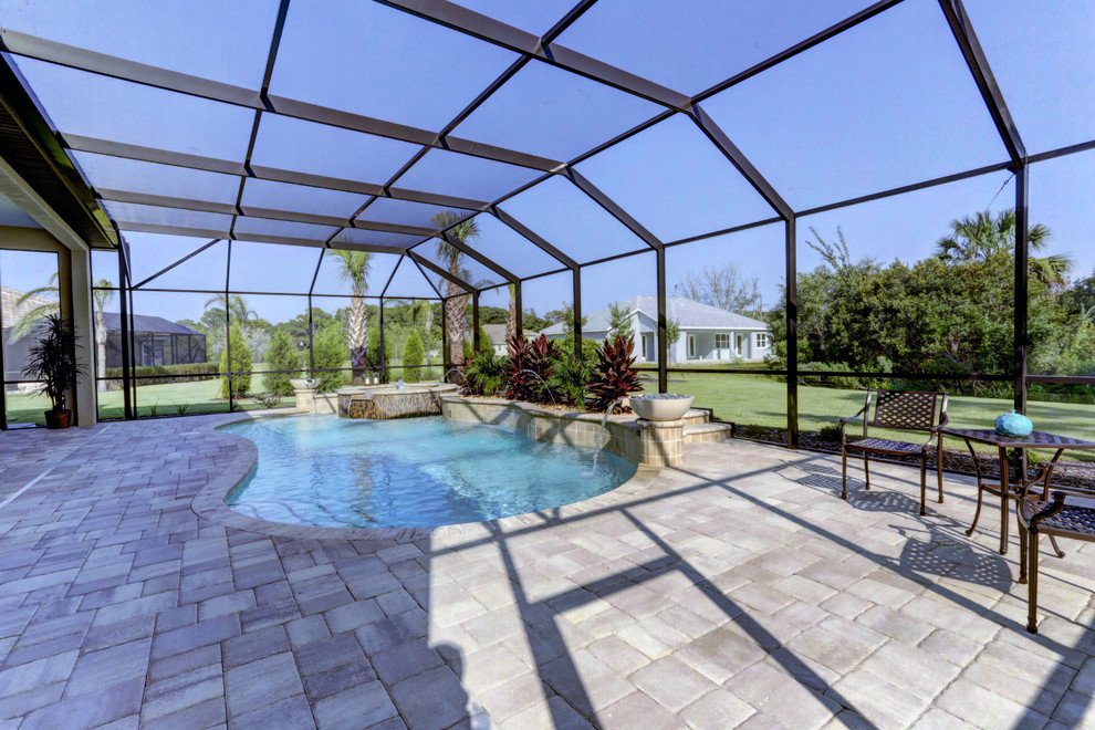 Großer Klassischer Schwimmteich hinter dem Haus in individueller Form mit Wasserspiel und Natursteinplatten in Orlando