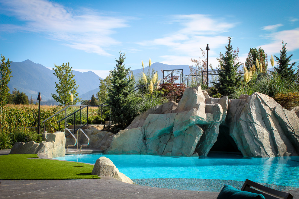 Großer Uriger Pool hinter dem Haus in individueller Form mit Wasserrutsche und Betonplatten in Vancouver