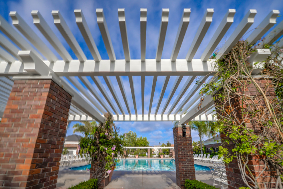 Foto de casa de la piscina y piscina alargada clásica renovada grande rectangular en patio trasero con adoquines de hormigón