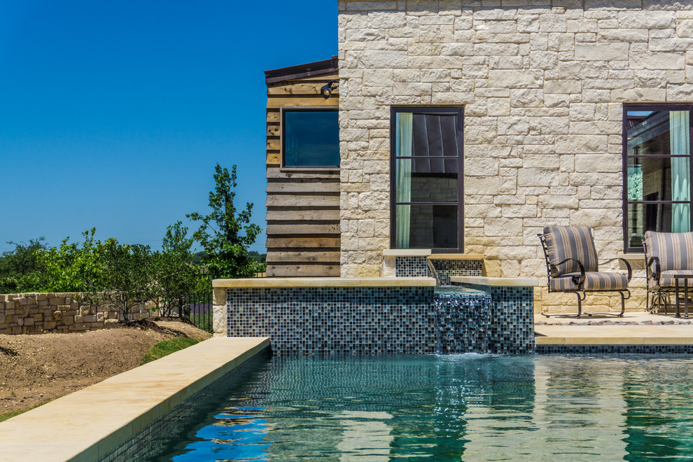 Diseño de piscinas y jacuzzis de estilo de casa de campo grandes rectangulares en patio trasero con adoquines de hormigón