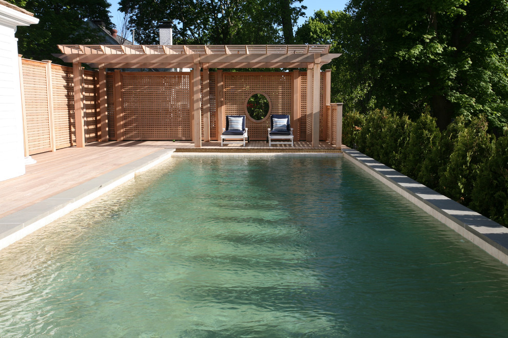 Diseño de piscinas y jacuzzis alargados rectangulares en patio trasero con adoquines de piedra natural