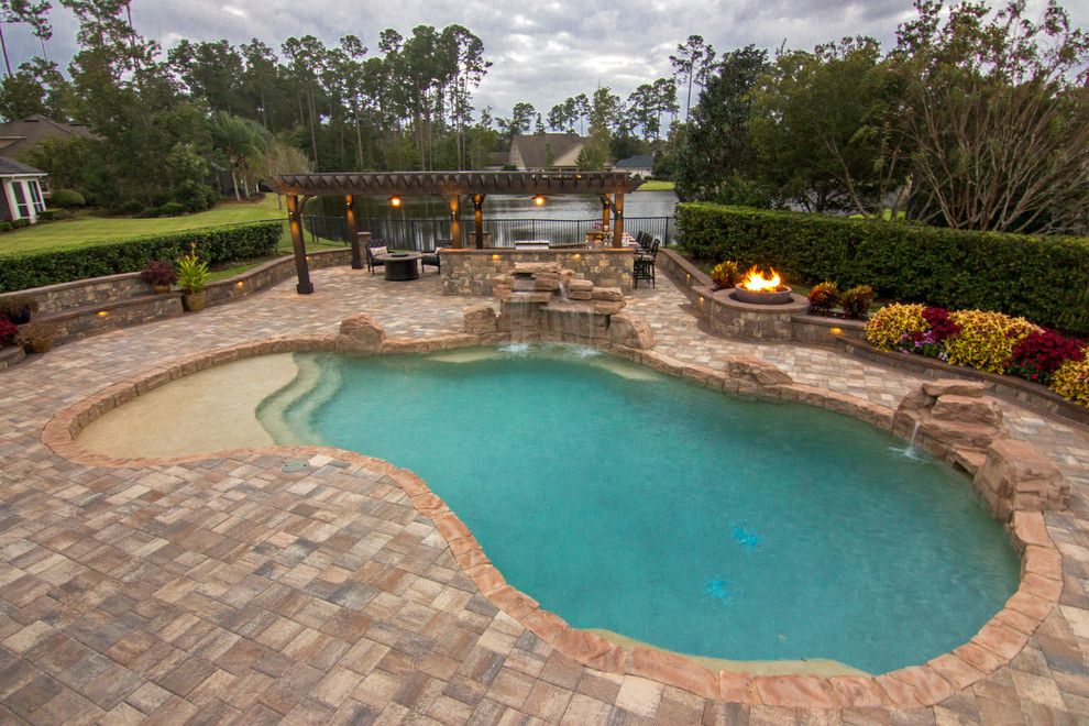 Immagine di una grande piscina fuori terra classica personalizzata dietro casa con fontane e pavimentazioni in pietra naturale