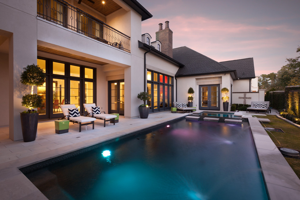 Foto di una grande piscina monocorsia design rettangolare dietro casa con una vasca idromassaggio e piastrelle