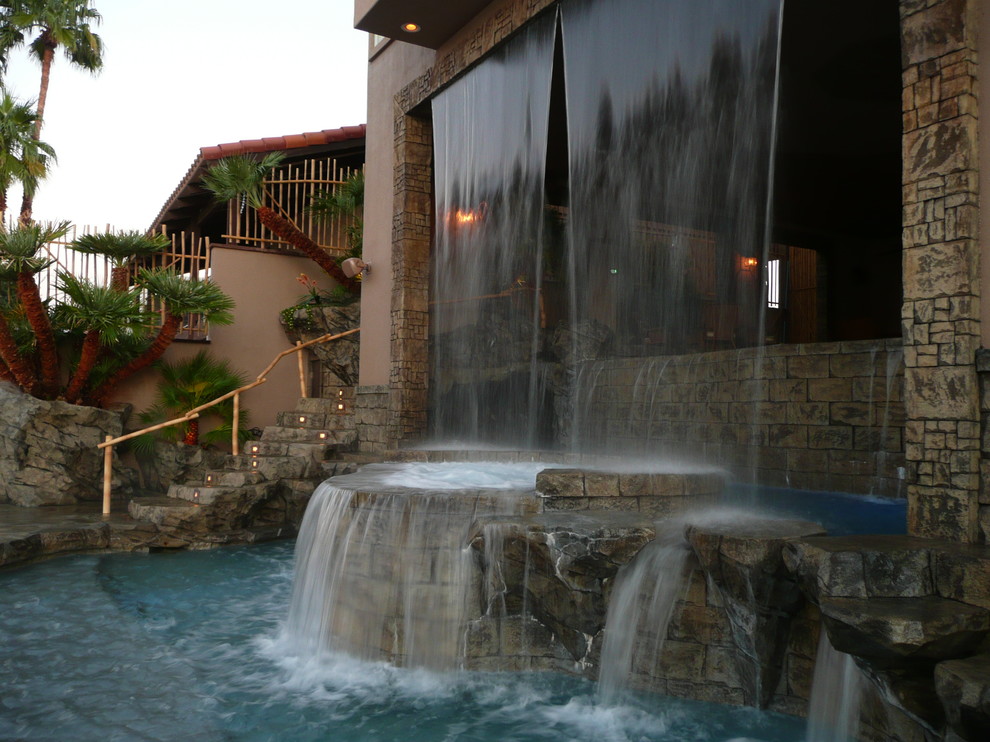 Diseño de piscinas y jacuzzis infinitos tropicales de tamaño medio a medida en patio trasero con suelo de hormigón estampado