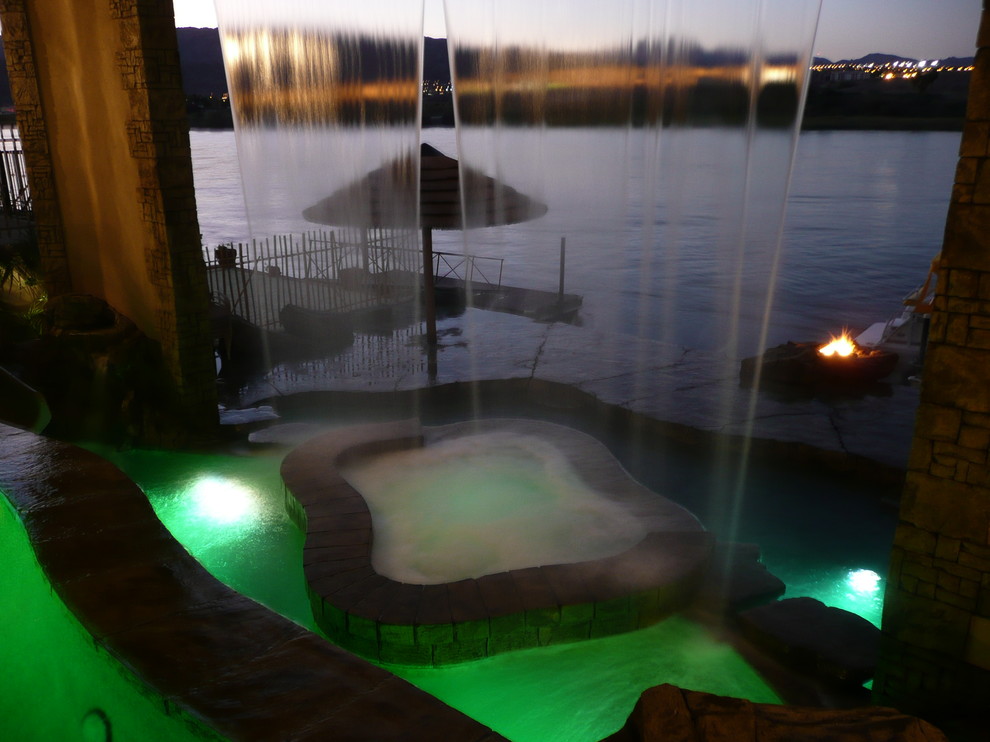 Idee per una piscina a sfioro infinito tropicale personalizzata dietro casa e di medie dimensioni con cemento stampato e una vasca idromassaggio