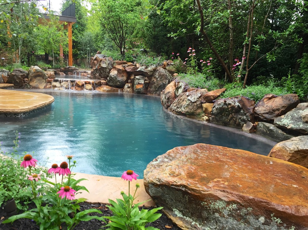 Diseño de piscina rústica pequeña a medida en patio trasero con adoquines de piedra natural
