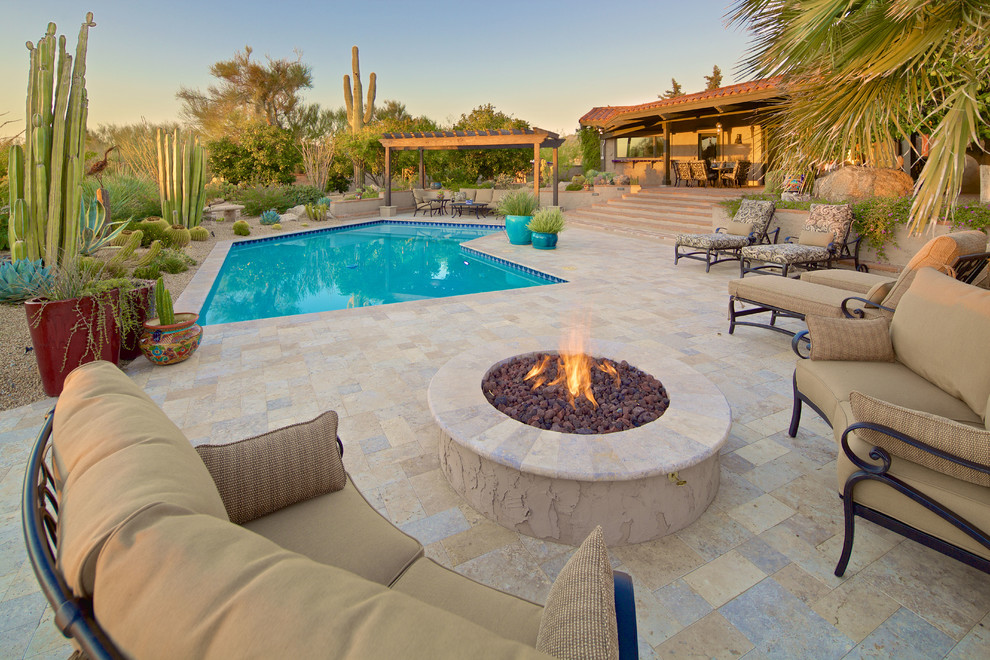 Large mediterranean back custom shaped natural swimming pool in Phoenix with concrete paving.