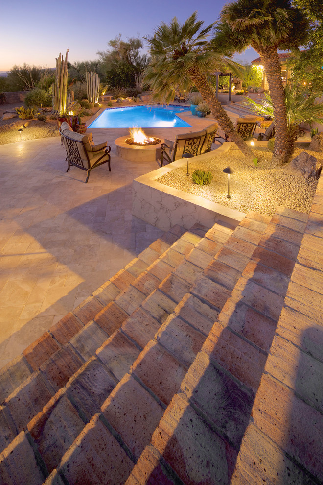 Large mediterranean back custom shaped natural swimming pool in Phoenix with concrete paving.