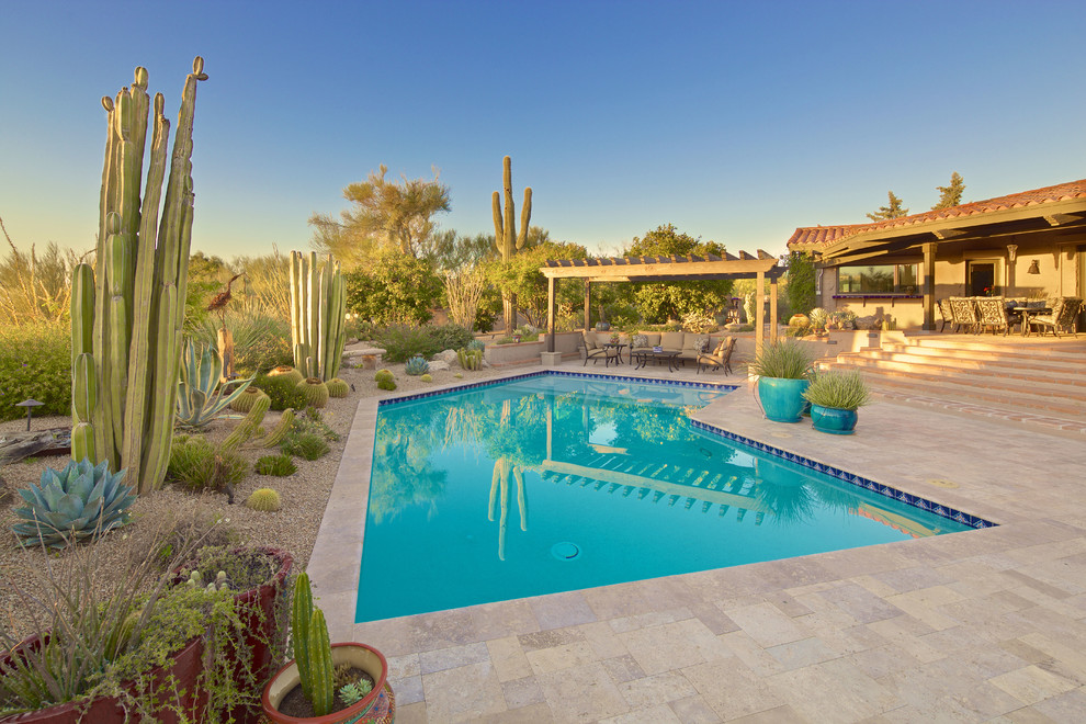 Diseño de piscina natural mediterránea grande a medida en patio trasero con adoquines de hormigón