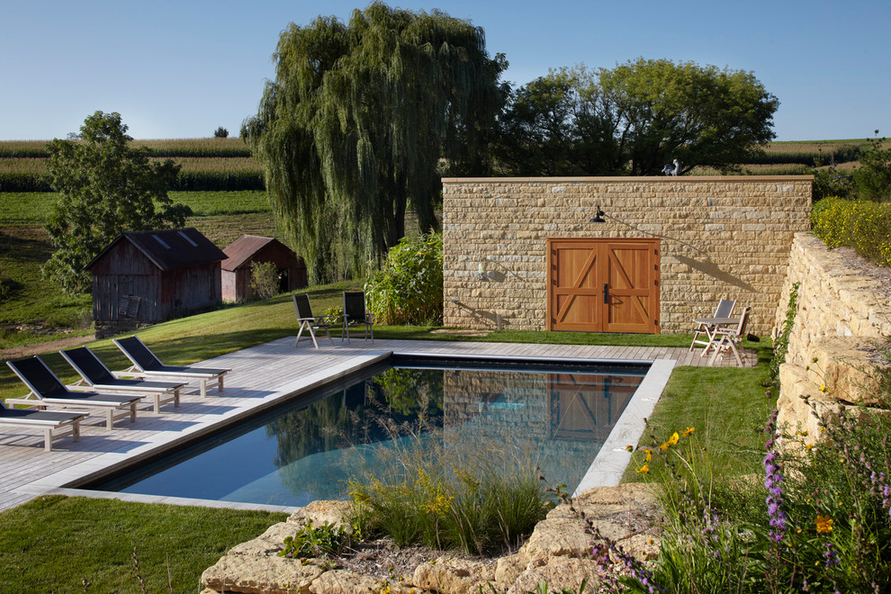 Idée de décoration pour une piscine champêtre rectangle avec une terrasse en bois.