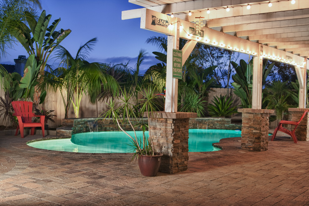 Idee per una grande piscina naturale rustica personalizzata dietro casa con fontane e pavimentazioni in cemento