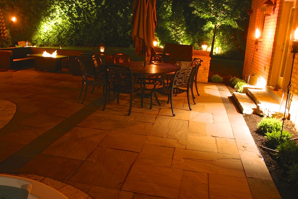 Medium sized contemporary back patio in Toronto with natural stone paving.