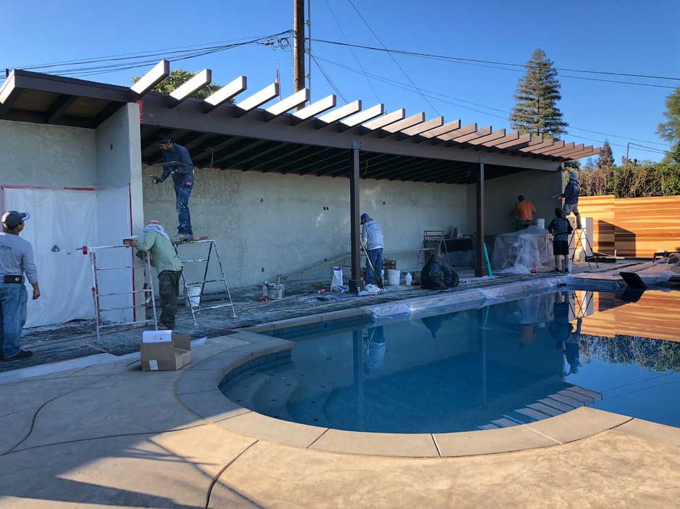 Cette photo montre un grand Abris de piscine et pool houses arrière chic sur mesure avec une dalle de béton.