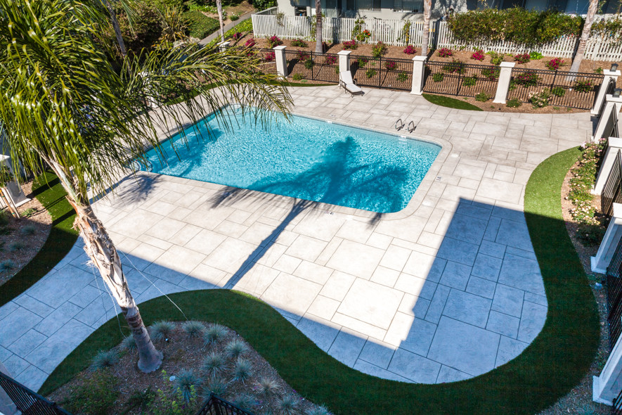 Imagen de piscina natural moderna grande rectangular en patio con suelo de hormigón estampado
