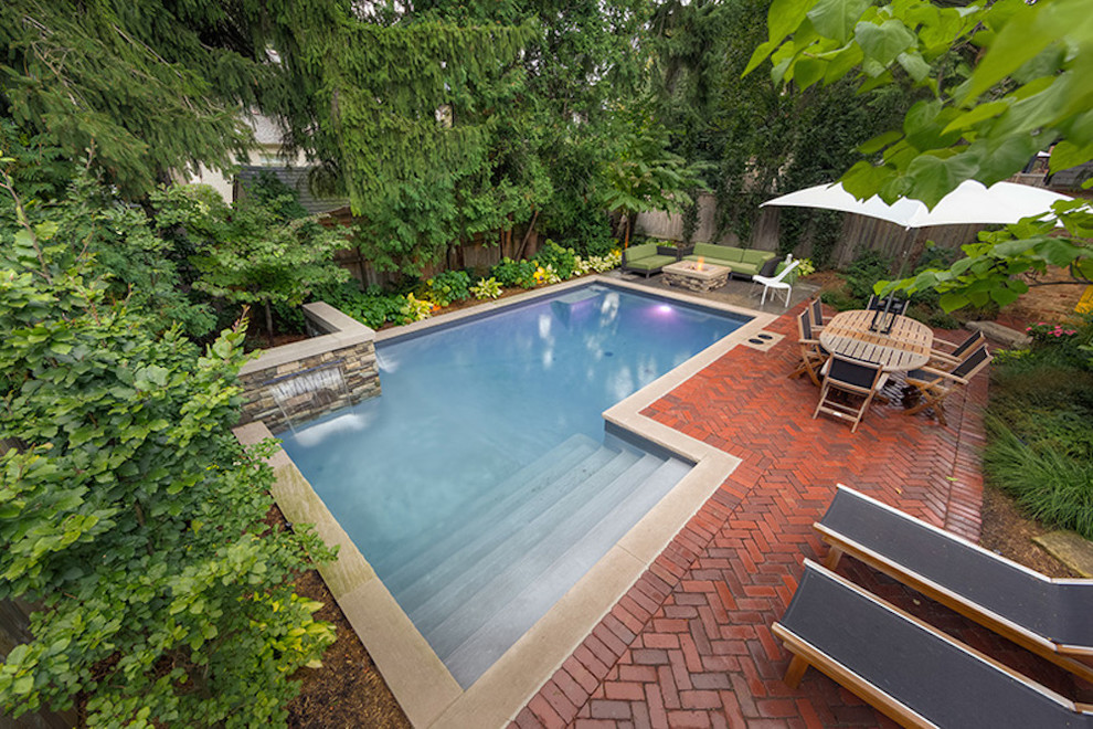 Imagen de piscinas y jacuzzis naturales tradicionales renovados de tamaño medio en forma de L en patio trasero con adoquines de ladrillo