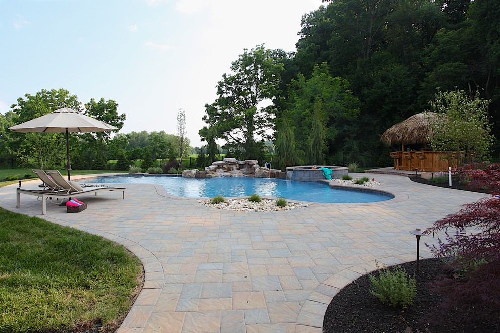Foto de casa de la piscina y piscina tradicional de tamaño medio a medida en patio trasero con adoquines de hormigón