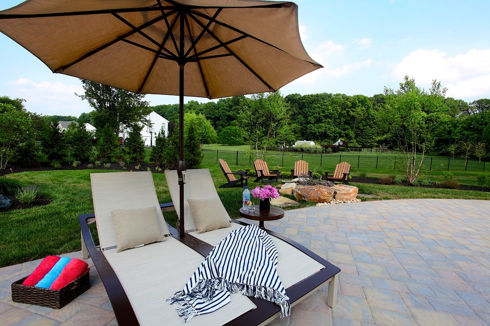 Mid-sized elegant backyard concrete paver and custom-shaped pool house photo in Philadelphia