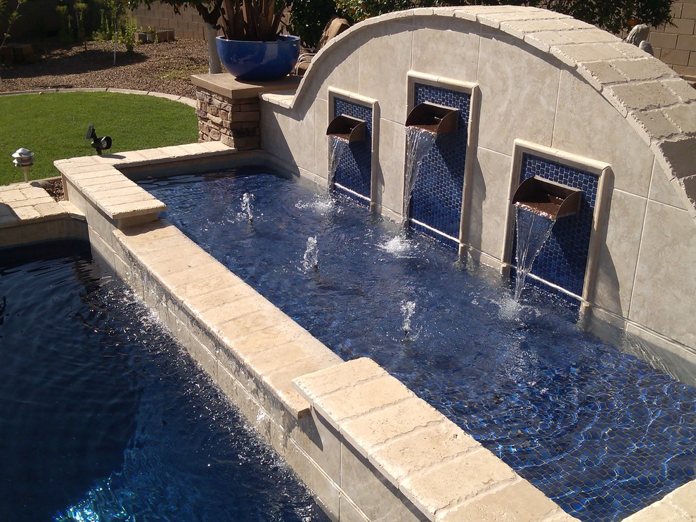 Foto de piscina tropical de tamaño medio rectangular en patio trasero con adoquines de piedra natural