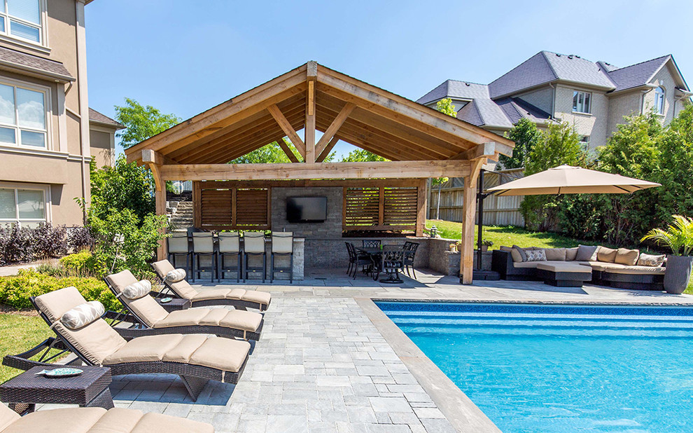 Inspiration for an expansive rustic back rectangular lengths swimming pool in Toronto with a pool house and concrete paving.