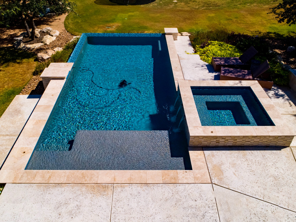 Inspiration for a large modern backyard concrete and rectangular infinity pool landscaping remodel in Austin