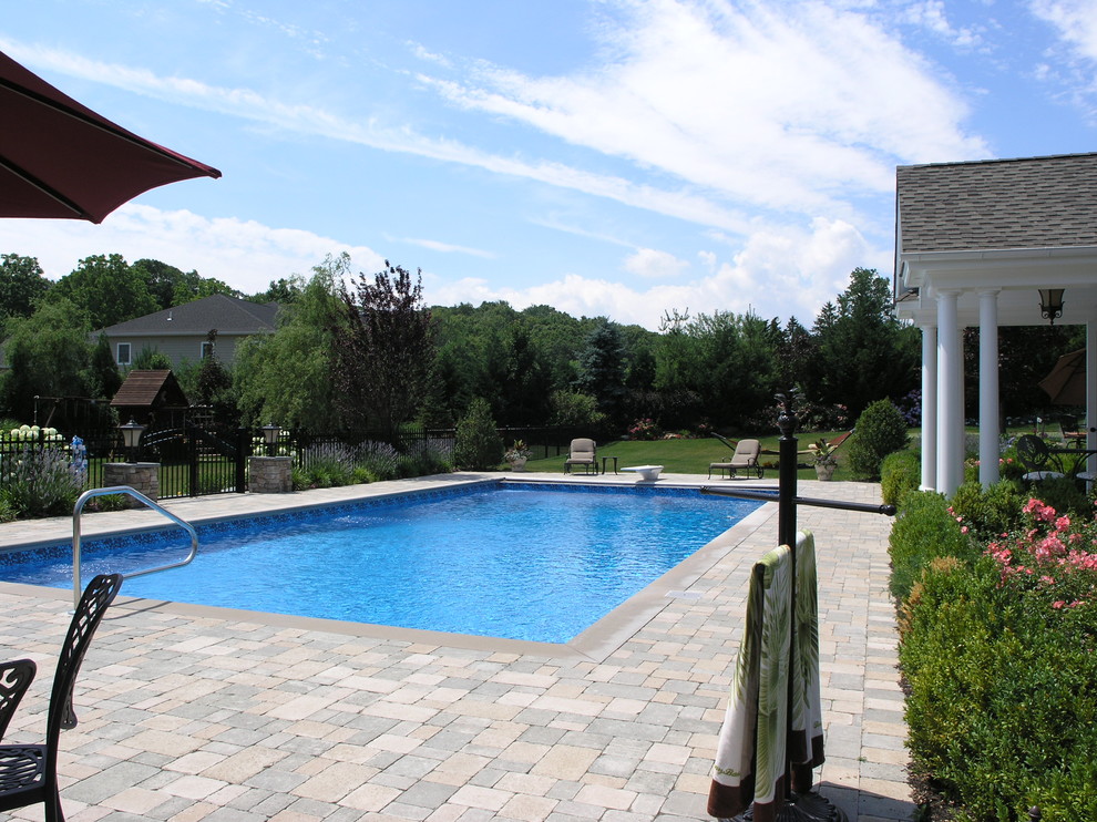 Ispirazione per una grande piscina classica rettangolare dietro casa con una dépendance a bordo piscina e pavimentazioni in cemento