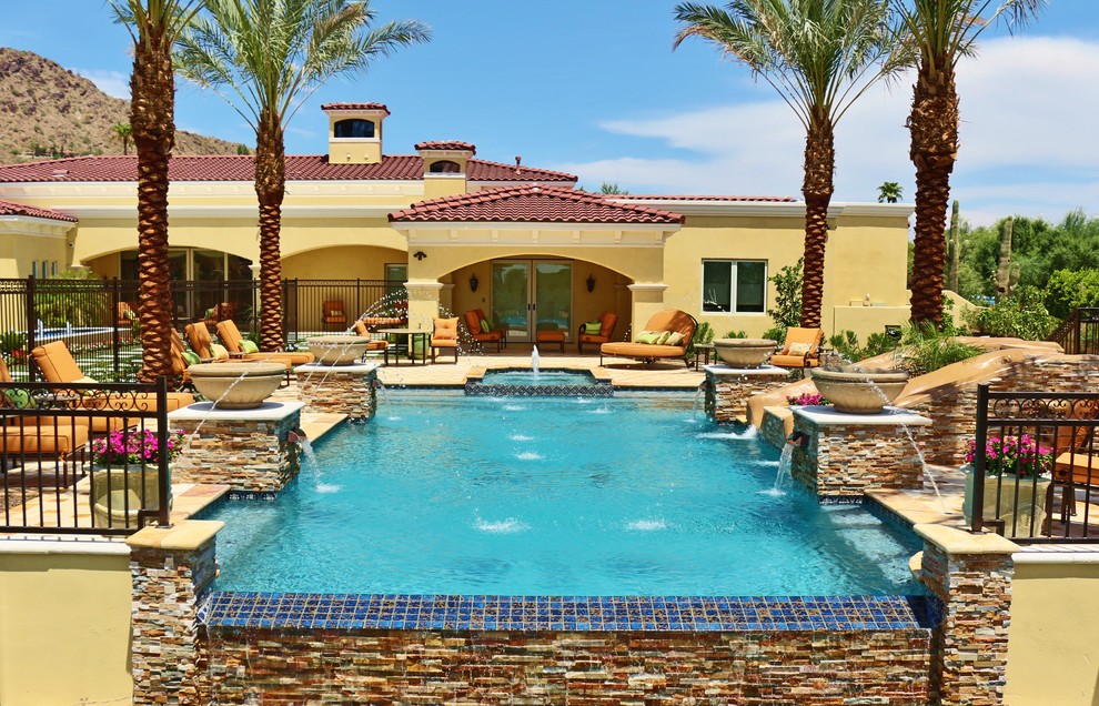 Diseño de piscinas y jacuzzis infinitos mediterráneos extra grandes rectangulares en patio trasero con adoquines de piedra natural