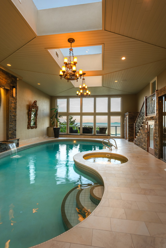 Photo of a traditional indoor kidney-shaped lengths hot tub in Vancouver with natural stone paving.