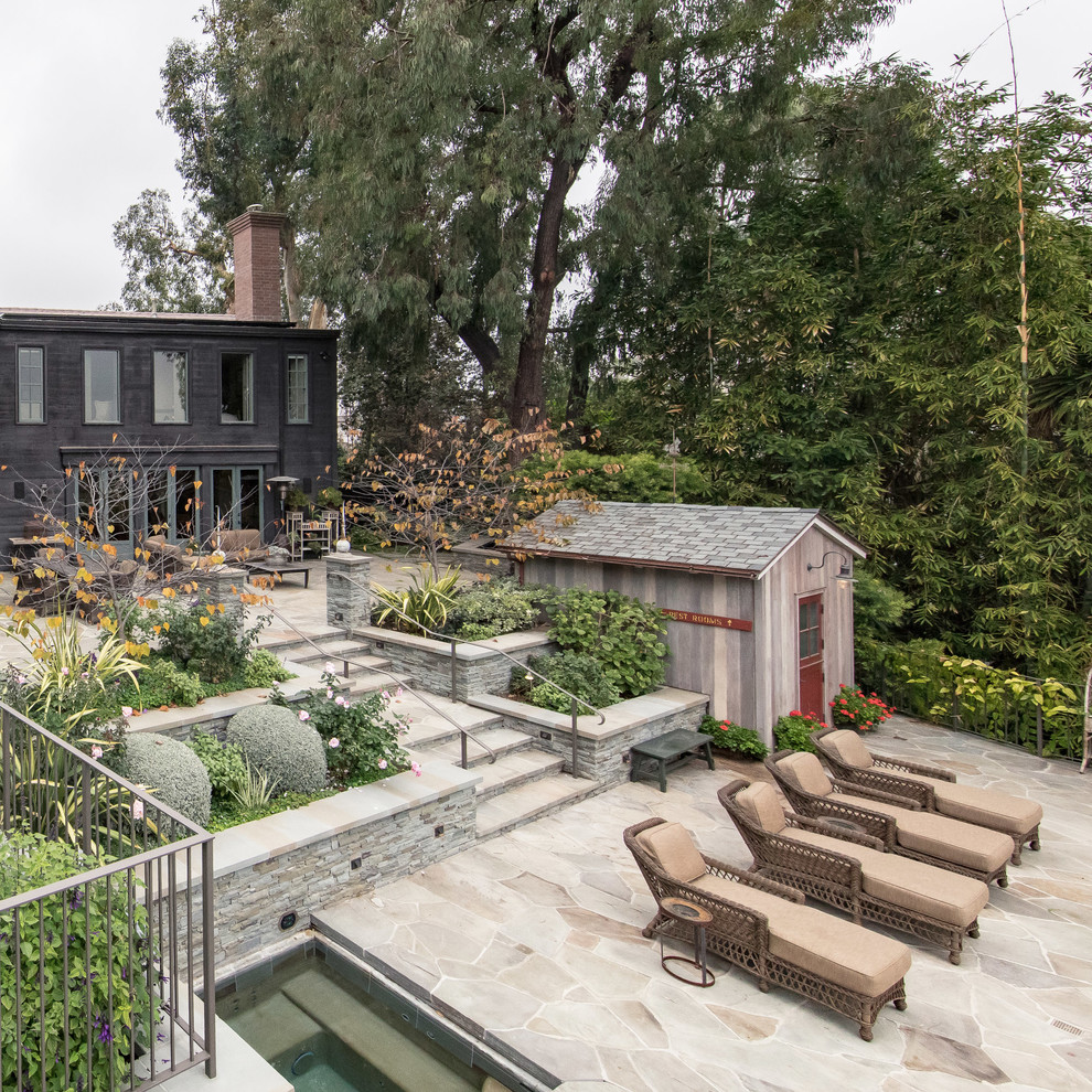Imagen de casa de la piscina y piscina de estilo de casa de campo en patio trasero con adoquines de piedra natural