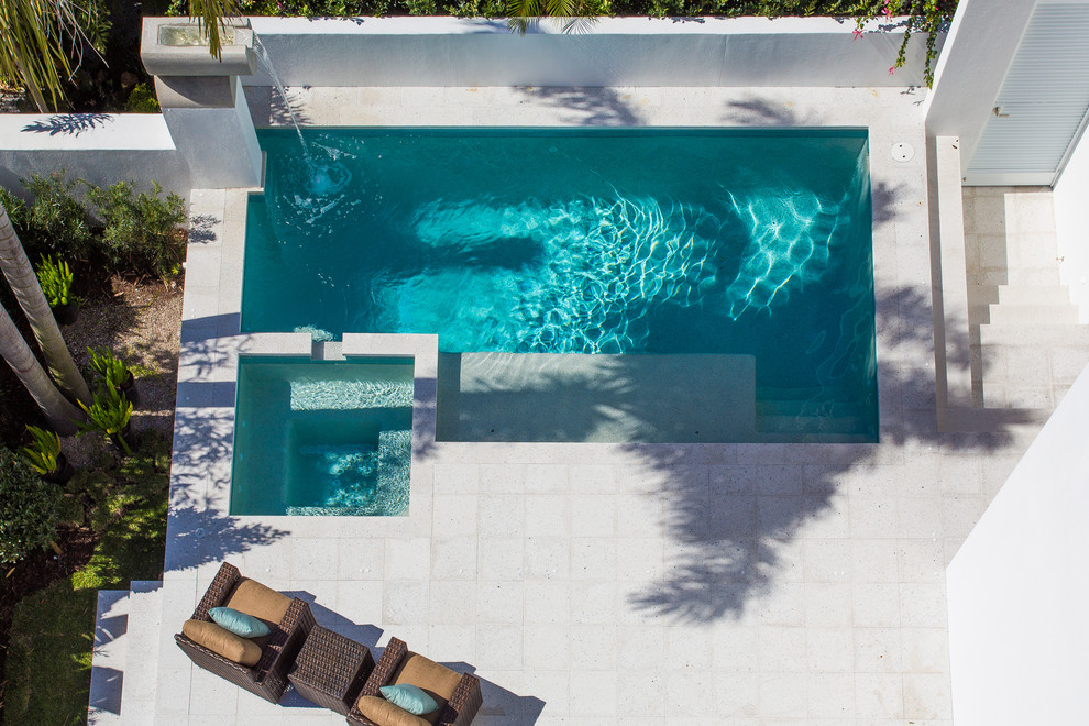 Idee per una piscina fuori terra minimalista rettangolare di medie dimensioni e davanti casa con fontane e pavimentazioni in cemento