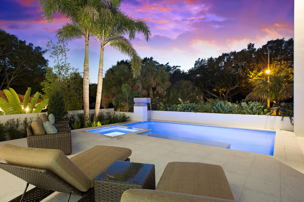 Mittelgroßer Moderner Schwimmteich hinter dem Haus in rechteckiger Form mit Wasserspiel und Betonboden in Tampa