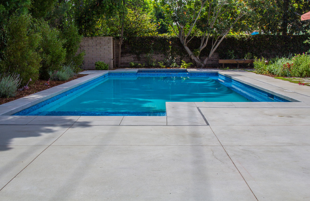 Идея дизайна: спортивный, прямоугольный бассейн среднего размера на заднем дворе в стиле ретро с джакузи и покрытием из бетонных плит