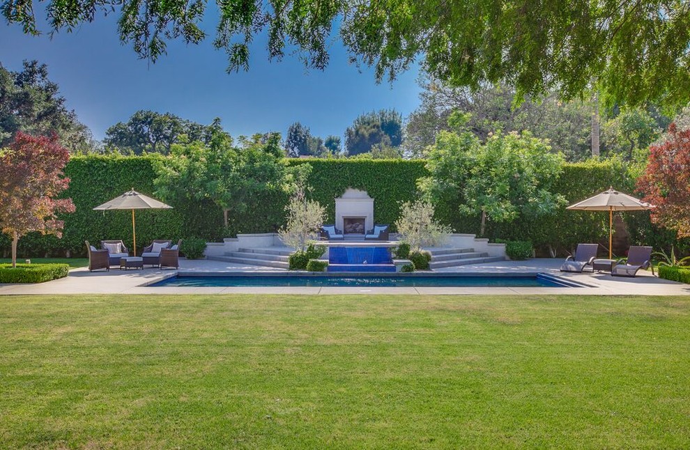 Mittelgroßer Klassischer Pool hinter dem Haus in rechteckiger Form mit Wasserspiel und Betonboden in Los Angeles