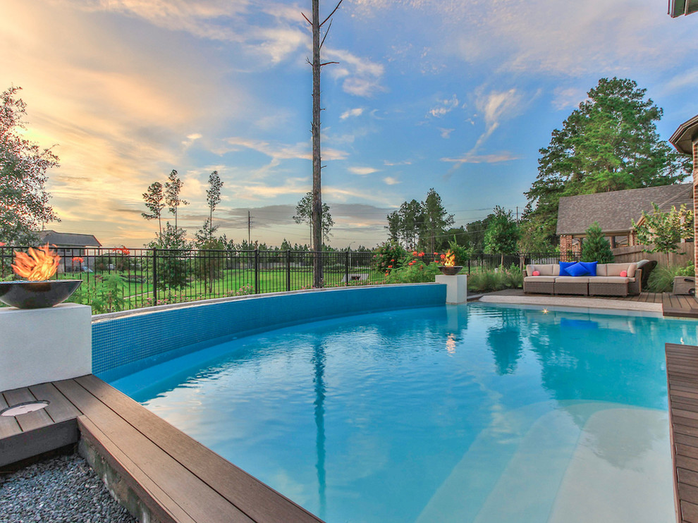 Cette photo montre une grande piscine naturelle et arrière chic rectangle avec un bain bouillonnant et une dalle de béton.