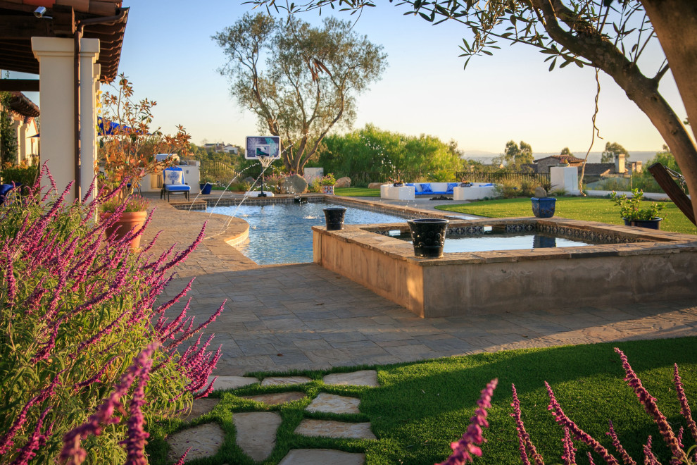 This is an example of a large mediterranean back rectangular lengths swimming pool in San Diego with with pool landscaping and concrete paving.