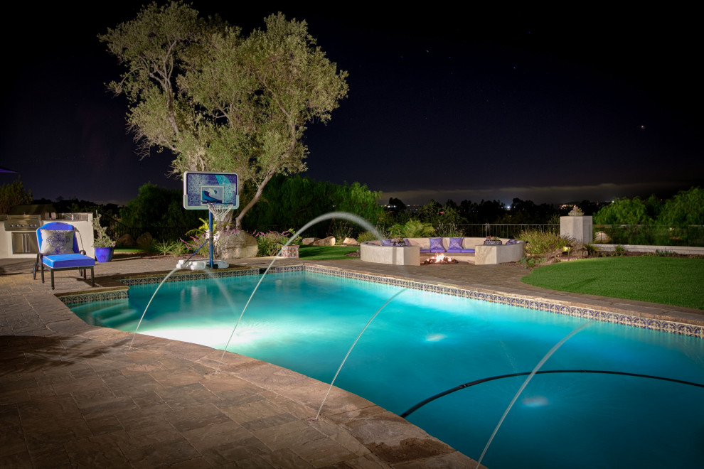 Idées déco pour une grande piscine arrière méditerranéenne rectangle avec des pavés en béton.