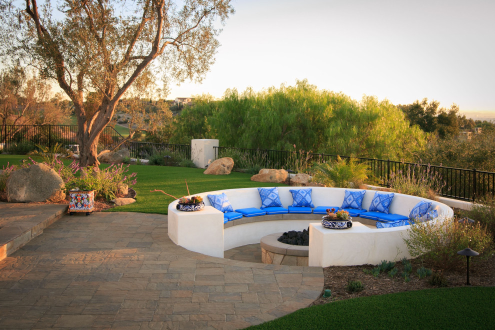 Foto de piscina alargada mediterránea grande rectangular en patio trasero con paisajismo de piscina y adoquines de hormigón