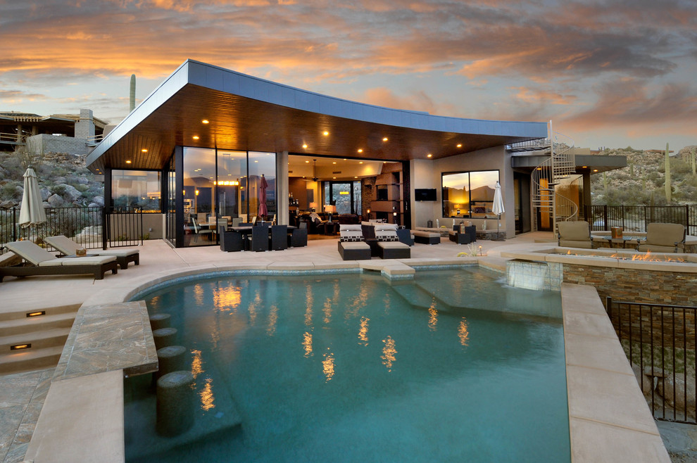 Immagine di una piscina design personalizzata di medie dimensioni e dietro casa con una vasca idromassaggio e piastrelle