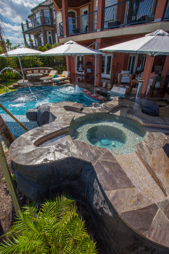 Ispirazione per una piscina a sfioro infinito tropicale personalizzata dietro casa