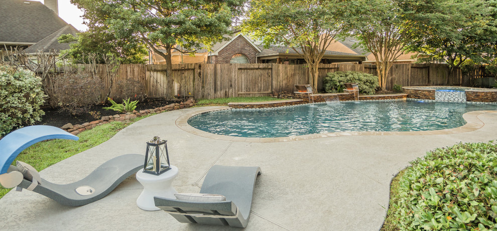 Example of a mid-sized trendy backyard tile and custom-shaped pool fountain design in Houston
