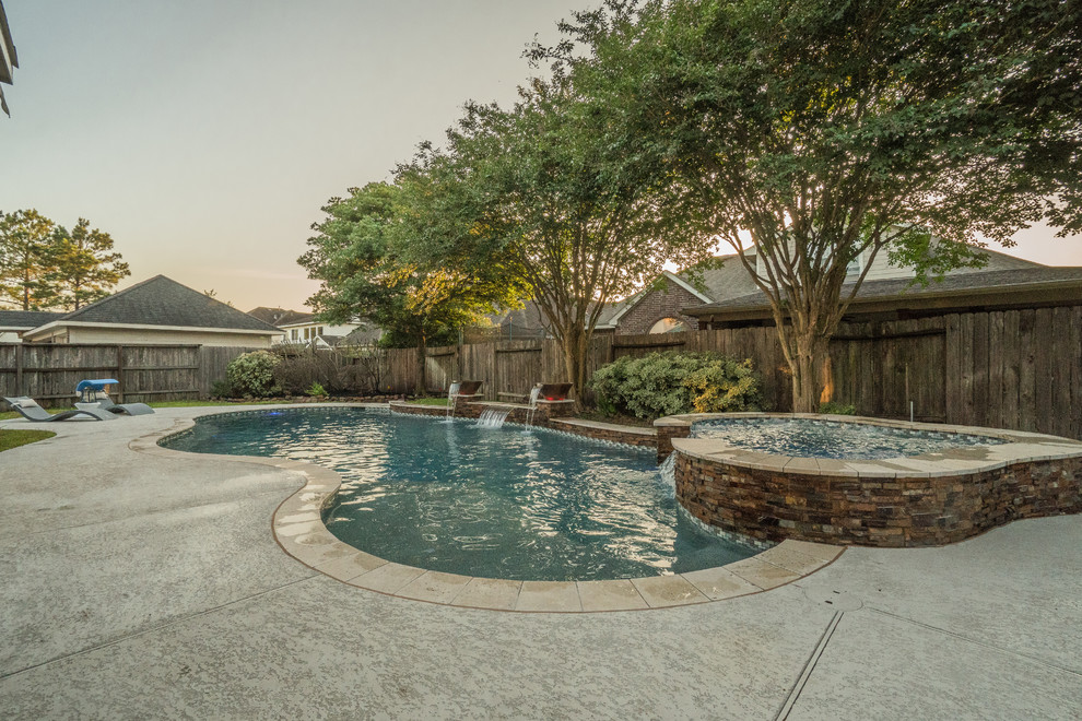 Mittelgroßer, Gefliester Moderner Pool hinter dem Haus in individueller Form mit Wasserspiel in Houston