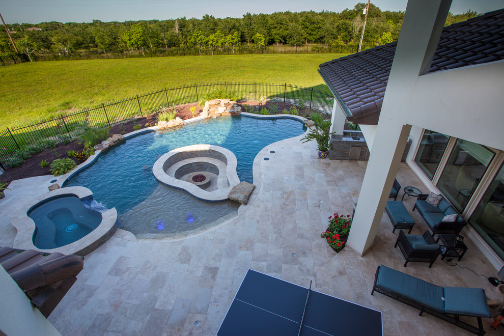 Moderner Pool hinter dem Haus in individueller Form mit Wasserspiel und Dielen in Houston