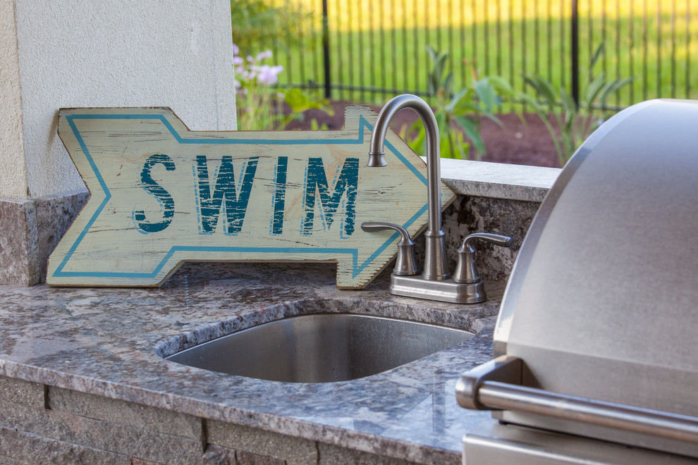 Esempio di una grande piscina minimal personalizzata dietro casa con fontane e pedane