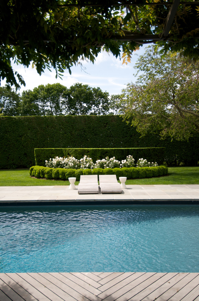 Idée de décoration pour une piscine tradition avec une terrasse en bois.