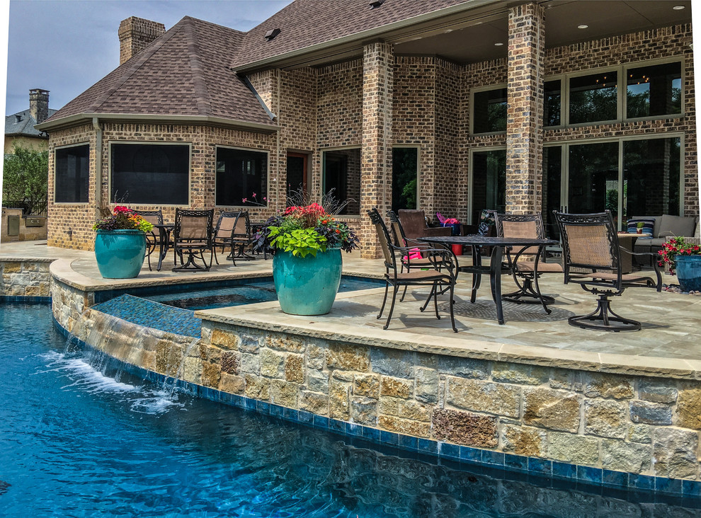 Esempio di una grande piscina a sfioro infinito classica personalizzata dietro casa con fontane e piastrelle