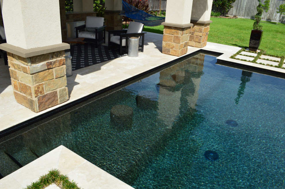 Ejemplo de casa de la piscina y piscina clásica grande a medida en patio trasero con adoquines de piedra natural