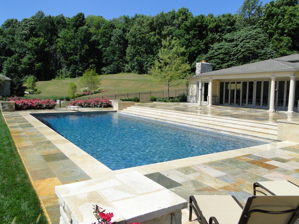 Ispirazione per una grande piscina monocorsia classica rettangolare dietro casa con pavimentazioni in pietra naturale