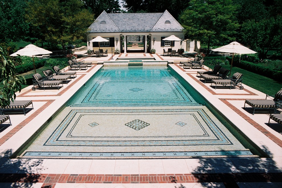 Immagine di un'ampia piscina monocorsia classica rettangolare dietro casa con pavimentazioni in pietra naturale e una vasca idromassaggio