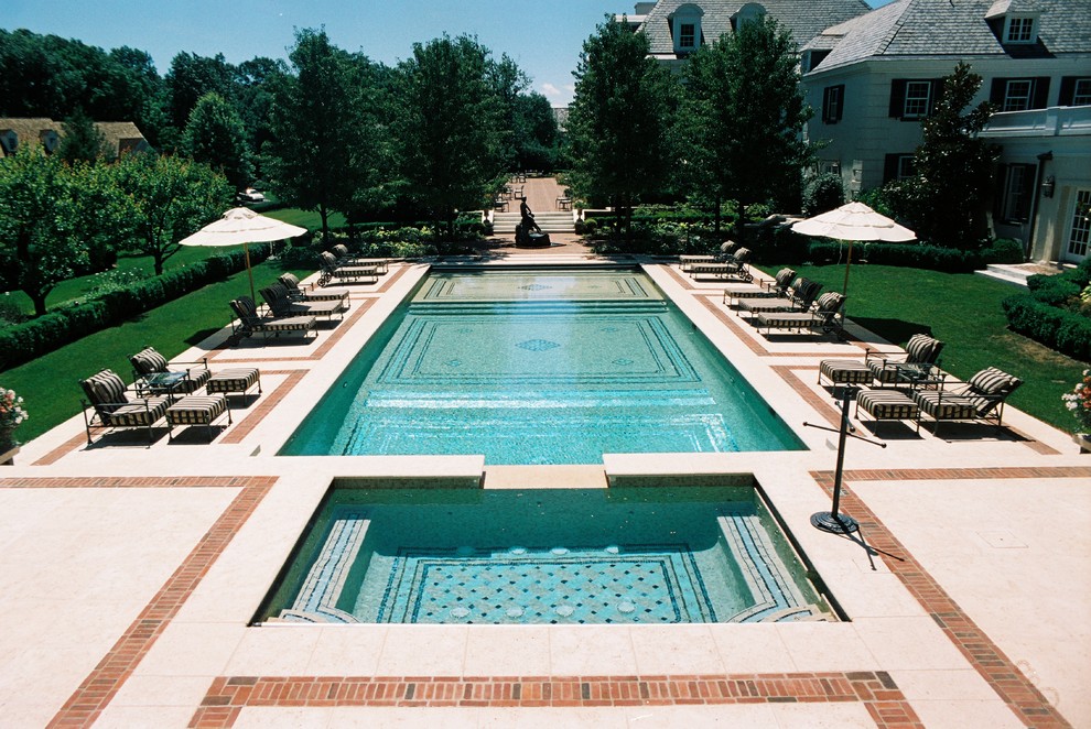 Idee per un'ampia piscina monocorsia classica rettangolare dietro casa con pavimentazioni in pietra naturale e una vasca idromassaggio