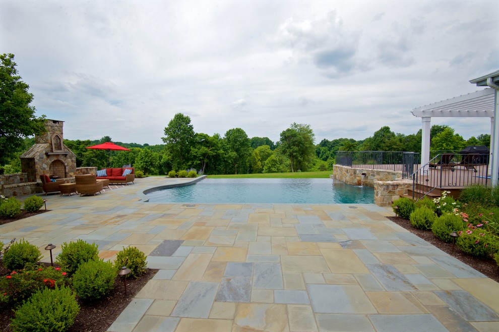 Idées déco pour une grande piscine à débordement et arrière classique rectangle avec un point d'eau et des pavés en pierre naturelle.